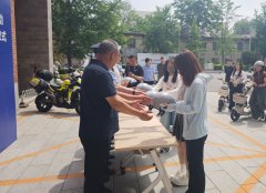 宾为学生代表发放平安头盔
